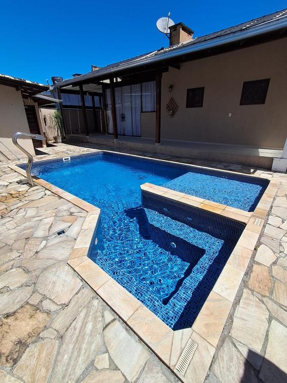 Piscina de alvenaria com pastilha azul e prainha, manutenção Guizoni Piscinas