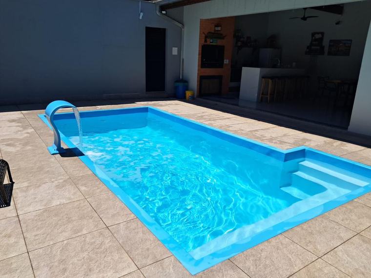 Piscina de fibra com cascata ao lado da área gourmet, água limpa e tratada