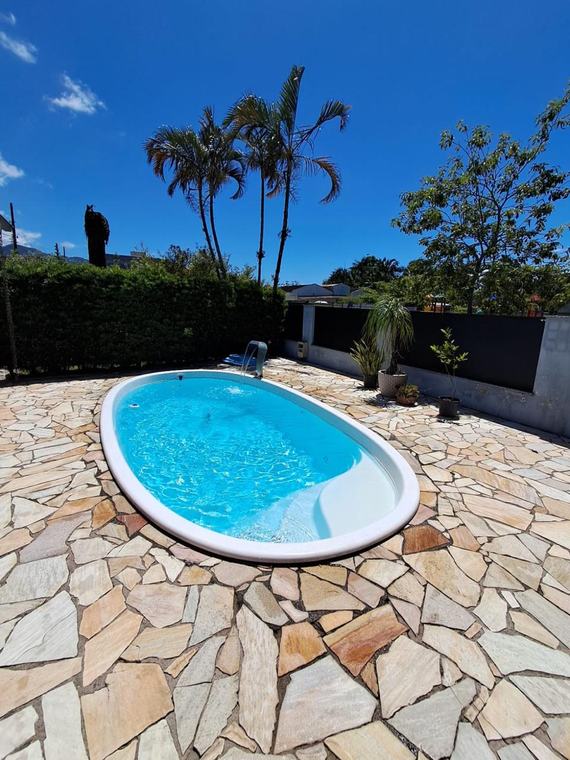 Piscina de fibra oval com piso de pedra, manutenção Guizoni Piscinas